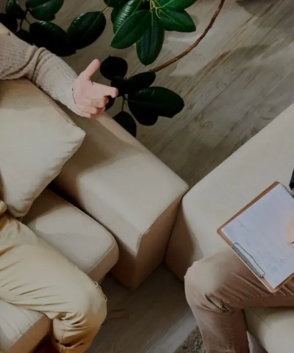 Two people seated across from a practitioner in a calm session room